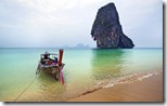 Fishing boat tied on a beach near limestone cliff, Railay Beach near Krabi, Thailand