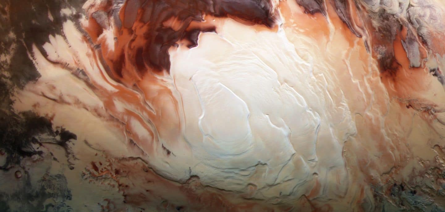 La región blanca brillante de esta imagen muestra la tapa helada que cubre el polo sur de Marte, compuesta de agua congelada y dióxido de carbono. Si bien se ve suave en esta imagen, en lugares cerrados la tapa es una mezcla en capas de picos, valles y llanuras planas. El casquete meridional alcanza unos 3 km de espesor en algunos lugares, y tiene alrededor de 350 km de diámetro.